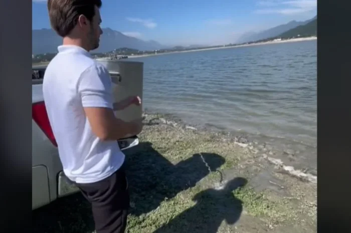 Joven vacía un bote con agua en la Presa La Boca para "ayudar" por la sequía