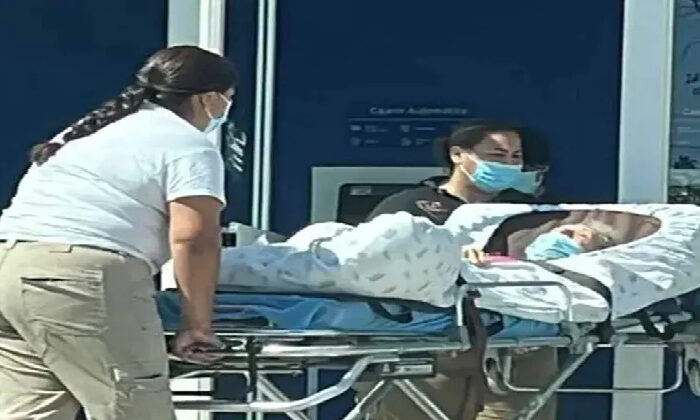 Familiares llevan en camilla a mujer de la tercera edad a un cajero
